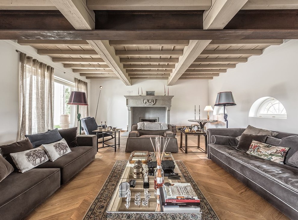 Diseño de salón para visitas abierto mediterráneo con paredes blancas, suelo de madera en tonos medios, todas las chimeneas, marco de chimenea de hormigón y suelo marrón