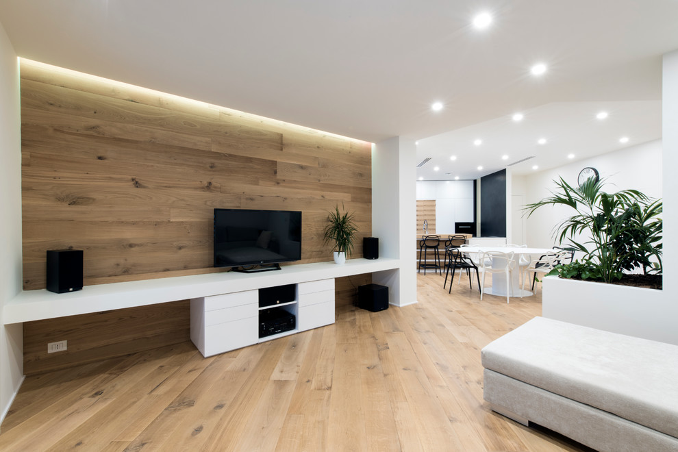 Ejemplo de sala de estar abierta contemporánea grande con paredes blancas, televisor independiente y suelo de madera clara