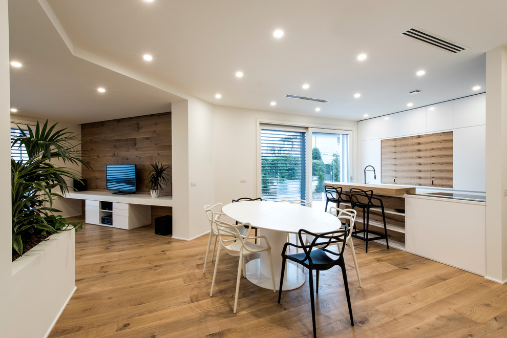 Diseño de salón abierto actual grande con paredes blancas, suelo de madera pintada y televisor independiente
