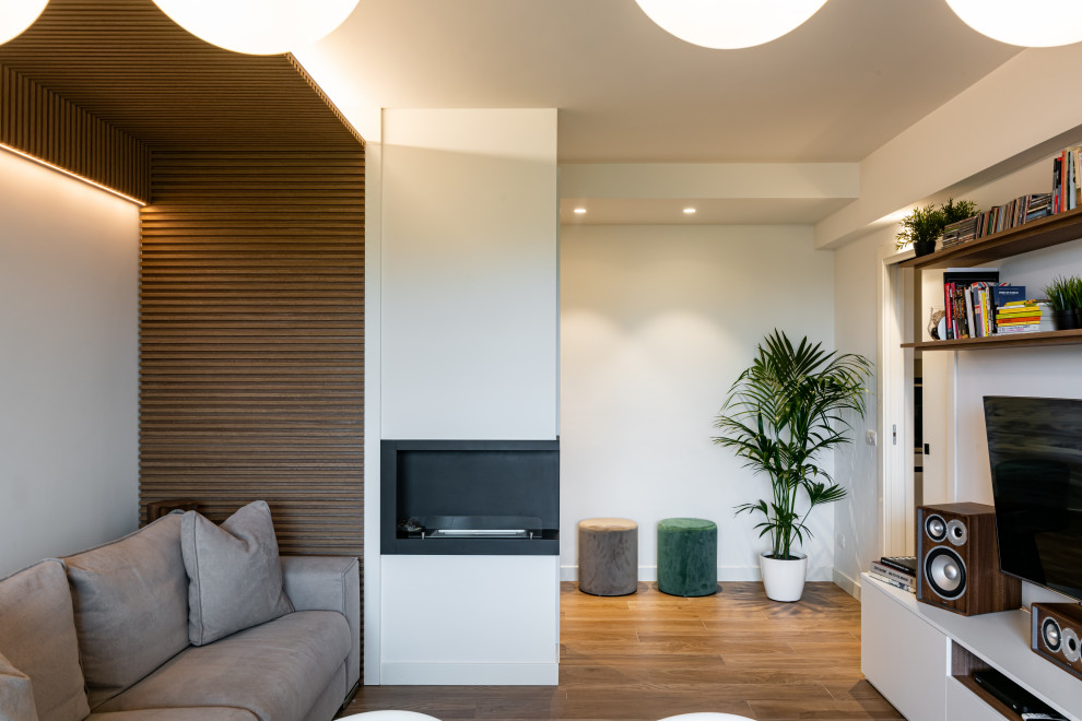 Exempel på ett mellanstort modernt separat vardagsrum, med ett finrum, vita väggar, klinkergolv i porslin, en standard öppen spis, en spiselkrans i metall, en inbyggd mediavägg och brunt golv