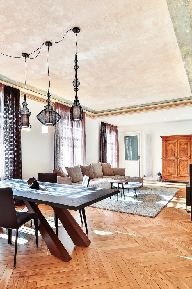 Immagine di un grande soggiorno design aperto con sala formale, pareti bianche, pavimento in legno massello medio e nessuna TV