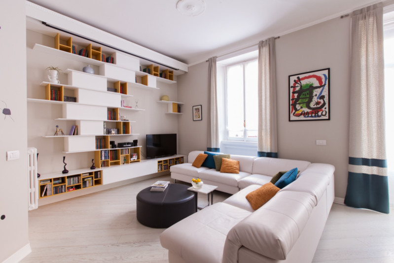 Ispirazione per un soggiorno design di medie dimensioni e aperto con libreria, parquet chiaro, TV autoportante, pavimento bianco e pareti grigie