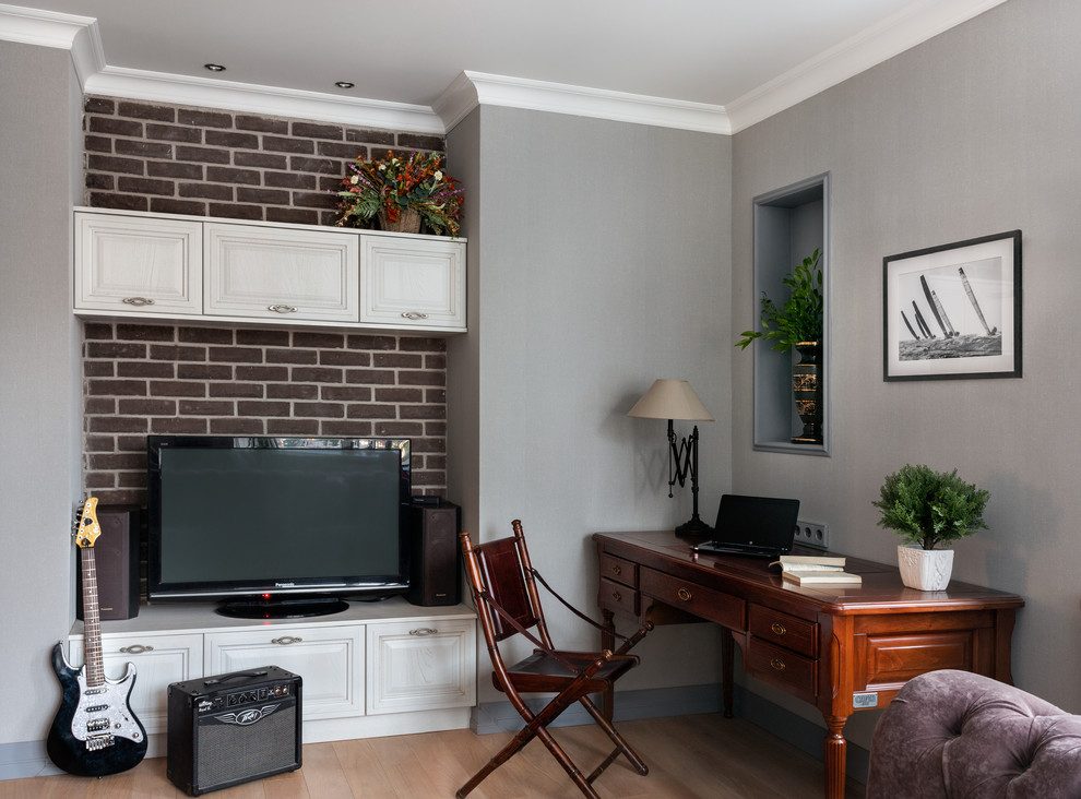 Modelo de salón clásico renovado de tamaño medio con paredes grises, suelo de madera clara, televisor independiente y suelo beige
