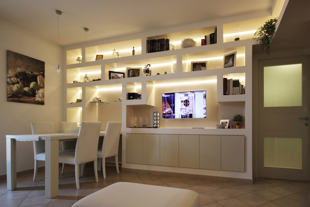 Modelo de biblioteca en casa abierta contemporánea pequeña con paredes blancas, suelo de baldosas de cerámica, pared multimedia y suelo beige