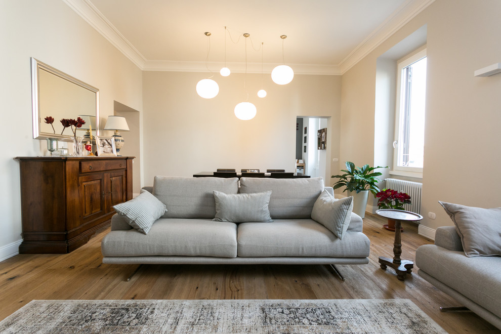 Diseño de salón abierto contemporáneo de tamaño medio con paredes beige y suelo de madera en tonos medios