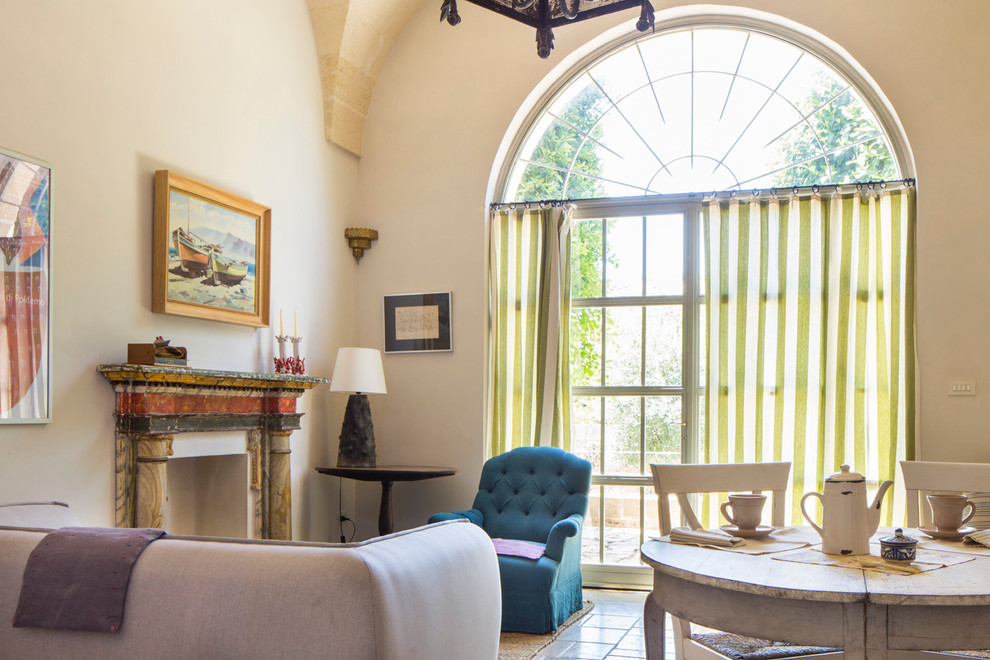 Пример оригинального дизайна: большая открытая гостиная комната в средиземноморском стиле с бежевыми стенами, полом из известняка, стандартным камином, фасадом камина из дерева и бежевым полом
