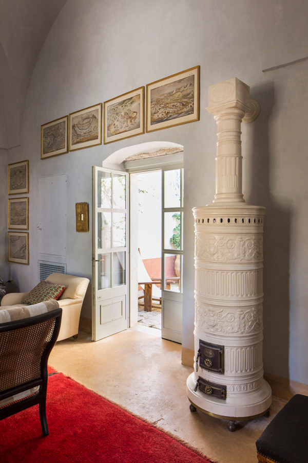 Источник вдохновения для домашнего уюта: огромная открытая гостиная комната в средиземноморском стиле с синими стенами, стандартным камином, фасадом камина из камня и бежевым полом