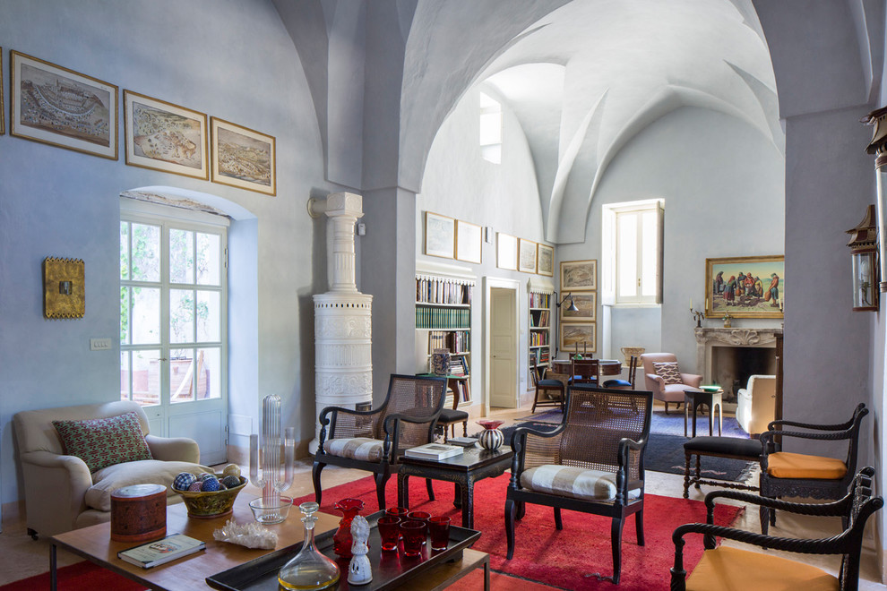 Foto de salón abierto mediterráneo extra grande con paredes azules, todas las chimeneas, marco de chimenea de piedra y suelo beige