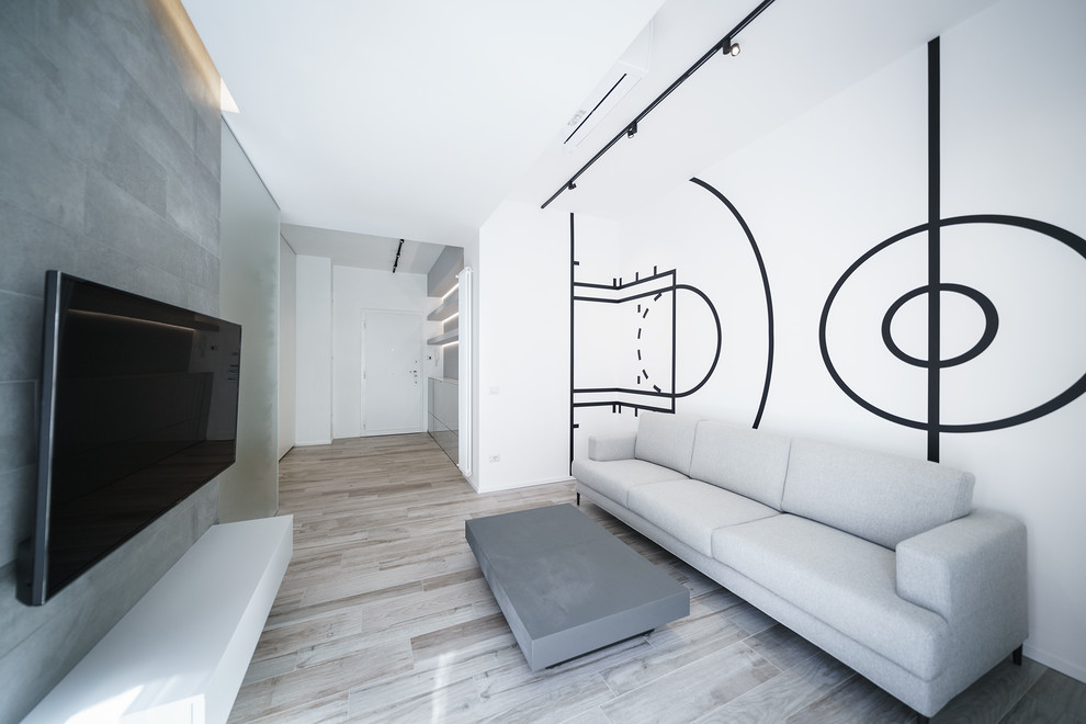 Esempio di un soggiorno minimalista con pareti multicolore, parquet chiaro, nessun camino e TV a parete