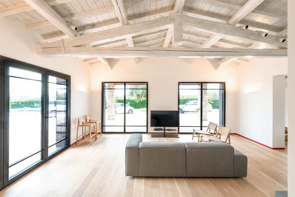 Foto di un ampio soggiorno minimalista con sala formale, pareti bianche, pavimento in legno massello medio e pavimento marrone