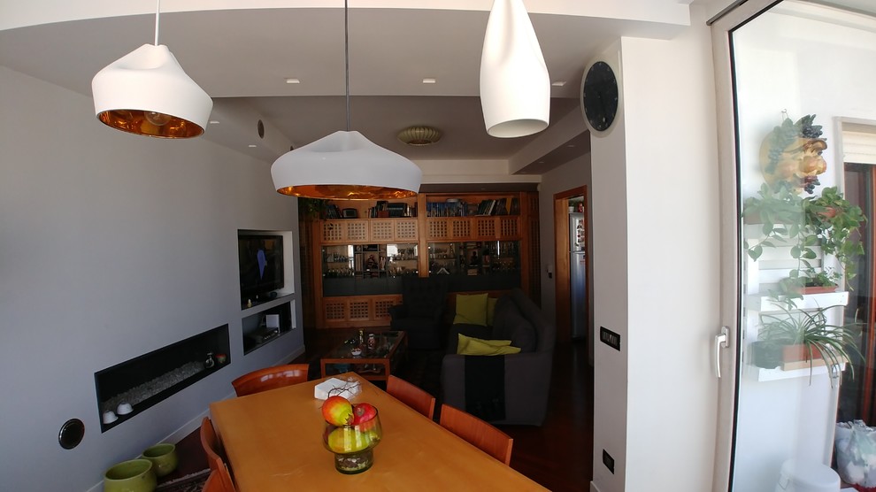 Пример оригинального дизайна: маленькая открытая гостиная комната в современном стиле с белыми стенами, деревянным полом, горизонтальным камином, фасадом камина из штукатурки, мультимедийным центром и коричневым полом для на участке и в саду