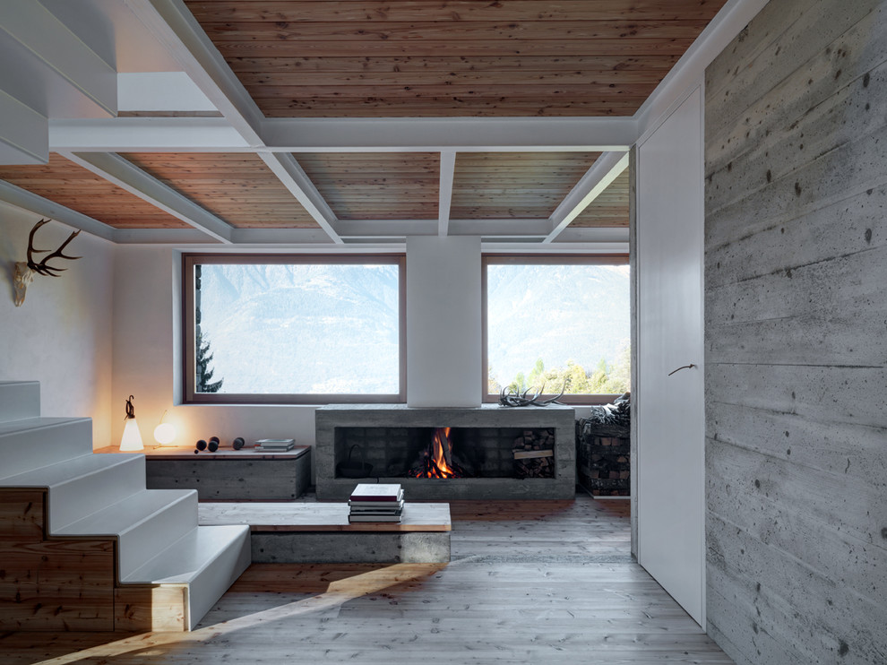 Uriges Wohnzimmer mit weißer Wandfarbe, braunem Holzboden, Kamin, Kaminumrandung aus Stein und braunem Boden in Mailand