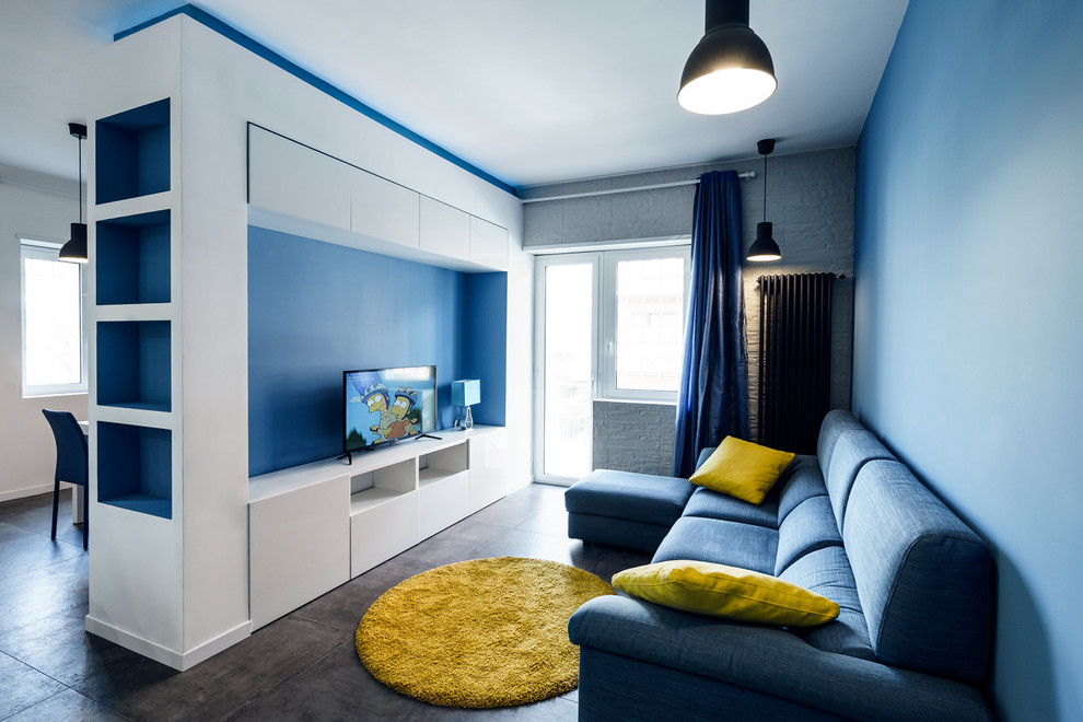Inredning av ett modernt mellanstort allrum med öppen planlösning, med blå väggar och en fristående TV