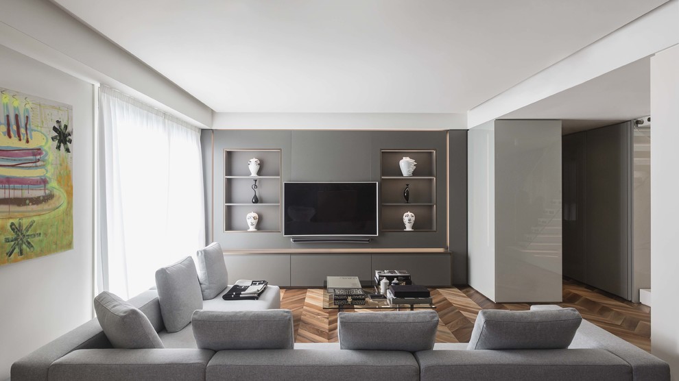 Ispirazione per un soggiorno minimal con pareti grigie, pavimento in legno massello medio, parete attrezzata e pavimento marrone
