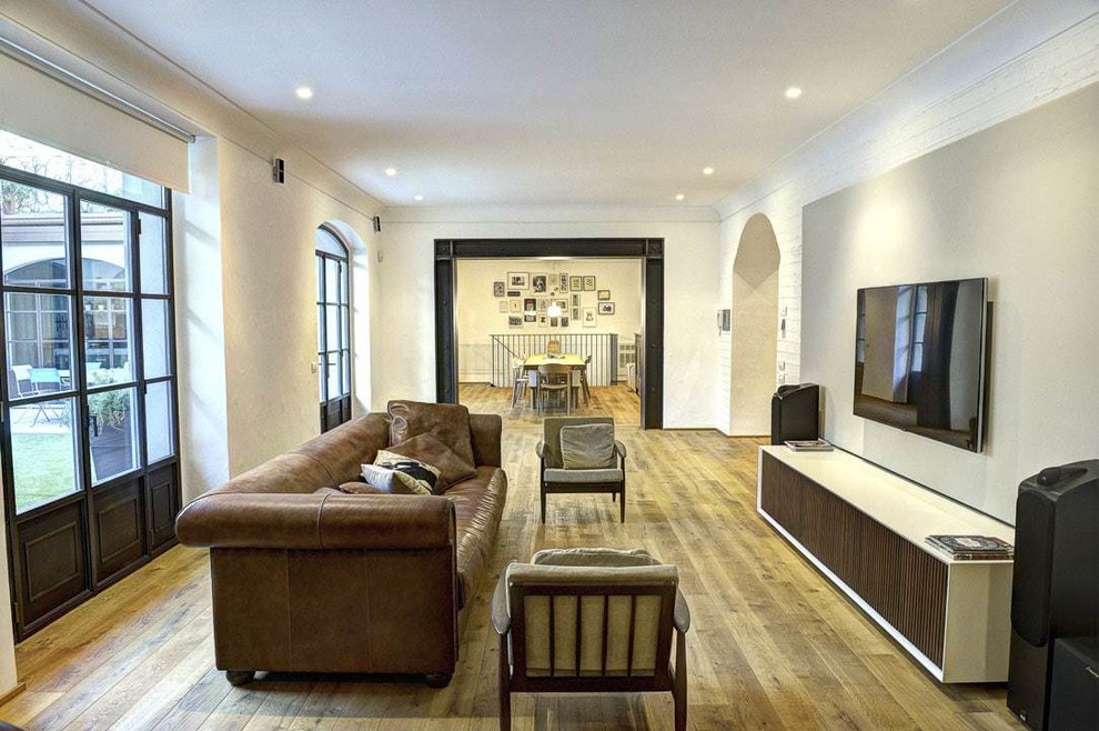 Mittelgroßes, Offenes Modernes Wohnzimmer mit weißer Wandfarbe, hellem Holzboden und TV-Wand in Mailand