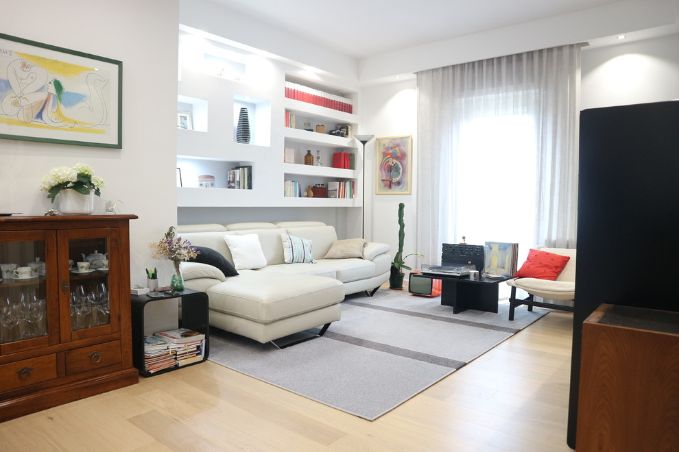 На фото: гостиная комната в современном стиле с с книжными шкафами и полками, белыми стенами и светлым паркетным полом