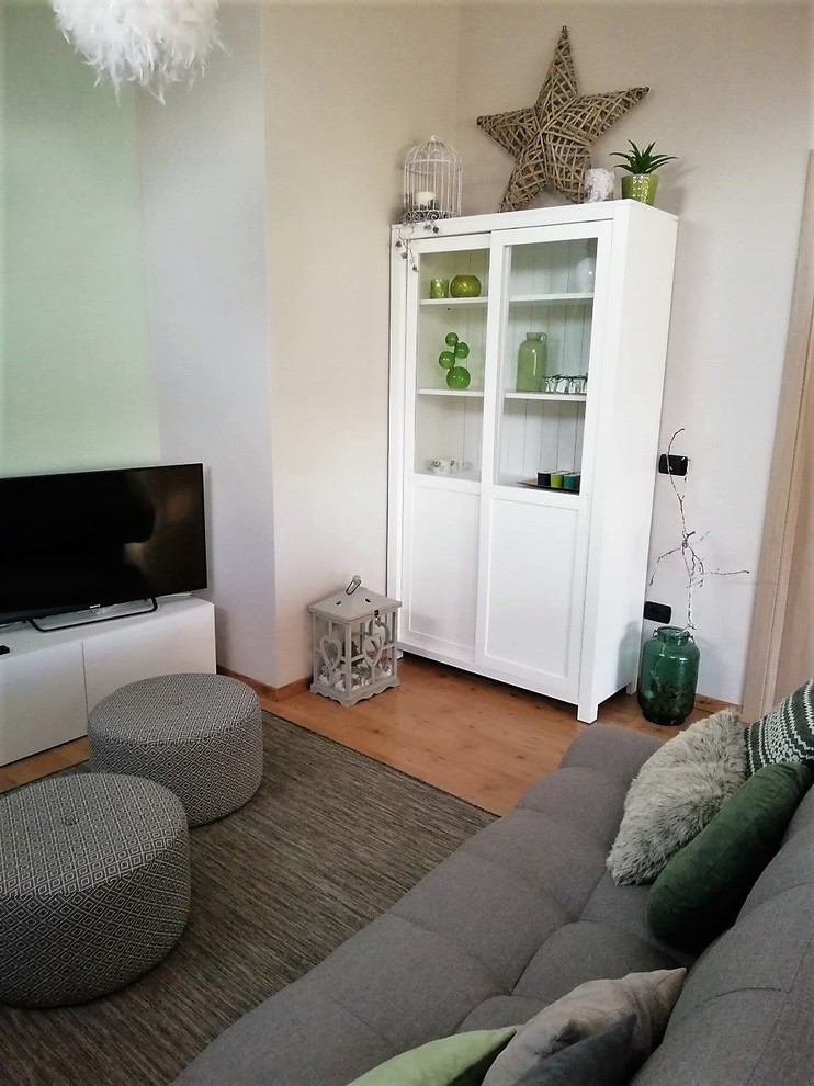 Mittelgroßes, Offenes Wohnzimmer mit bunten Wänden, braunem Holzboden, Kaminofen und braunem Boden in Mailand