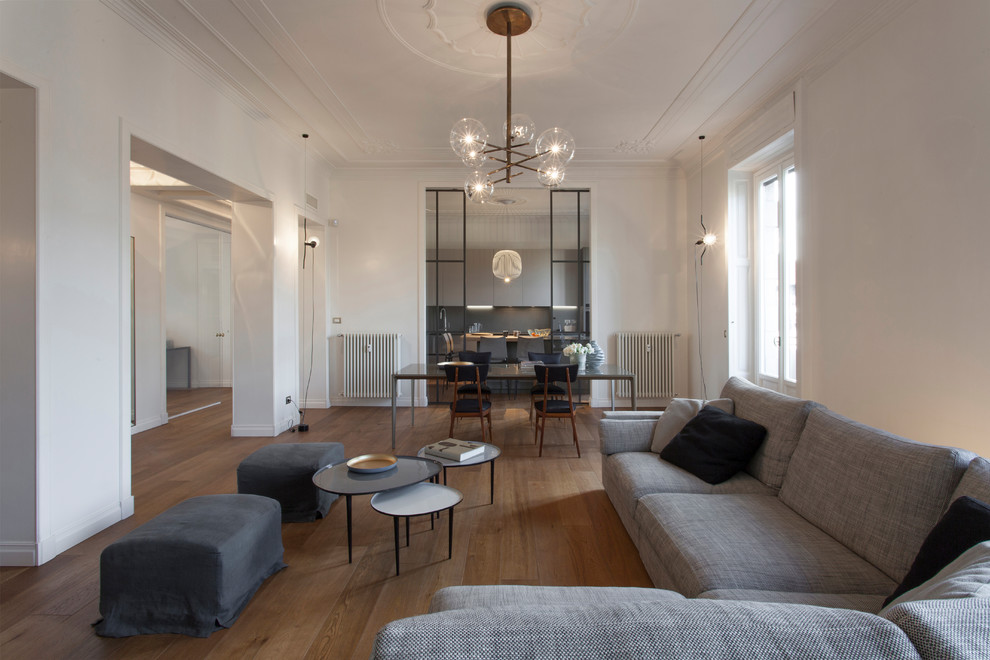 Diseño de salón para visitas abierto contemporáneo de tamaño medio sin chimenea y televisor con paredes blancas, suelo de madera en tonos medios y suelo marrón