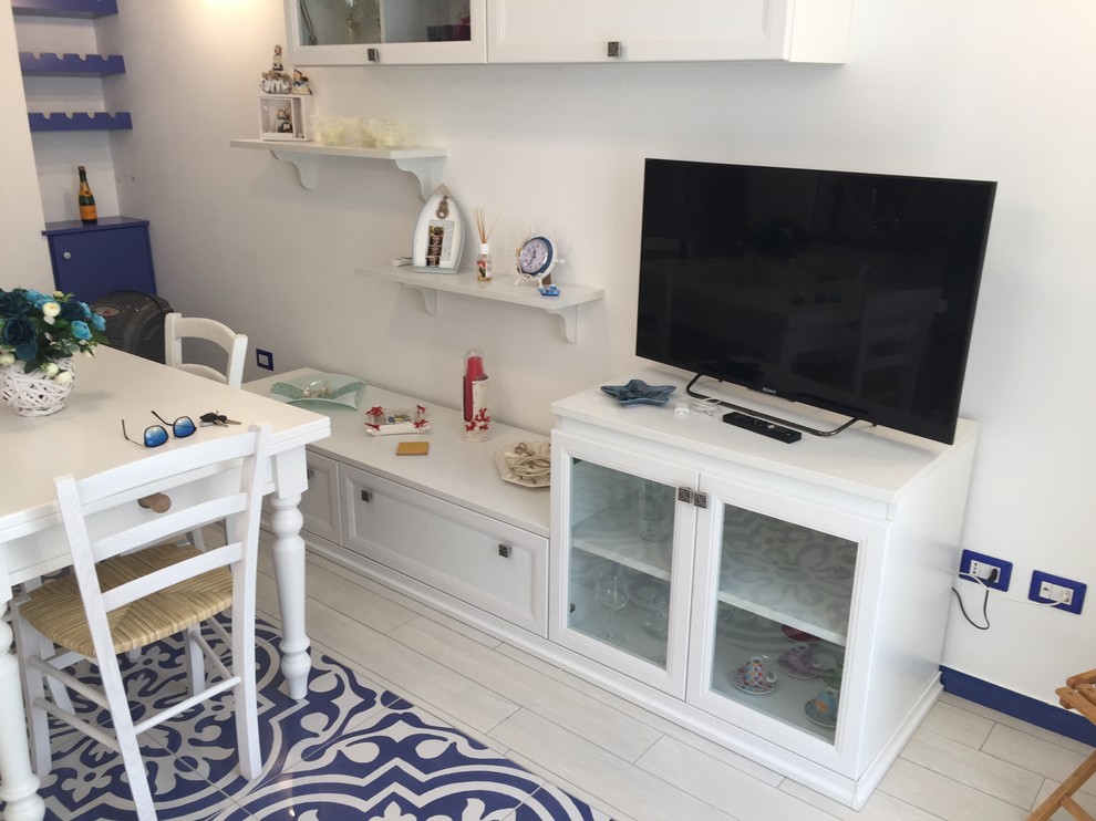 Cette image montre un petit salon méditerranéen avec un mur blanc, un sol en carrelage de porcelaine, aucune cheminée et un téléviseur indépendant.