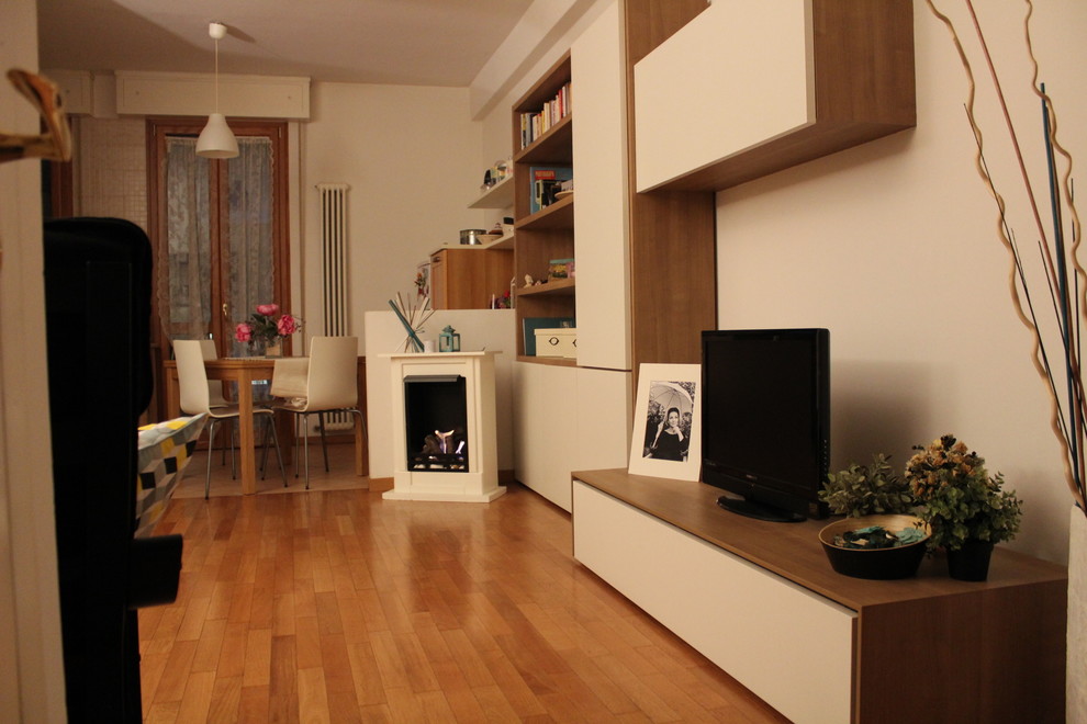 Foto di un piccolo soggiorno design aperto con pareti bianche, pavimento in legno massello medio e stufa a legna