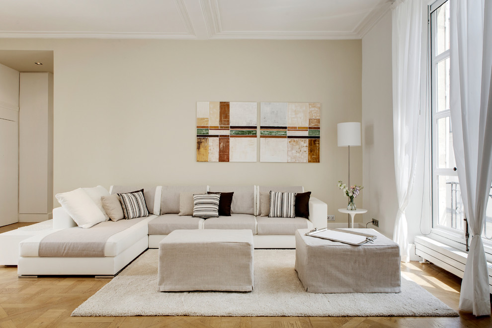 Foto di un soggiorno minimal con pareti beige e parquet chiaro