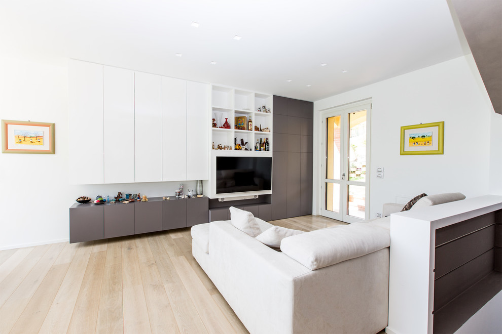 Идея дизайна: гостиная комната среднего размера в современном стиле с белыми стенами, светлым паркетным полом и телевизором на стене
