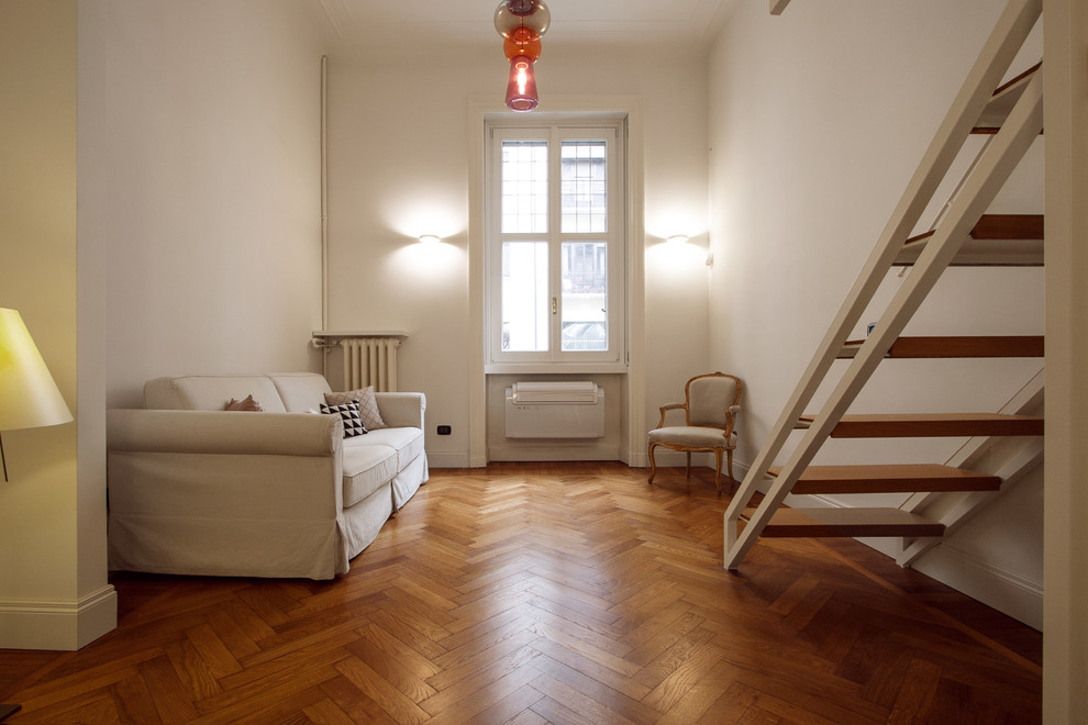 На фото: двухуровневая гостиная комната среднего размера в стиле ретро с белыми стенами, паркетным полом среднего тона и коричневым полом