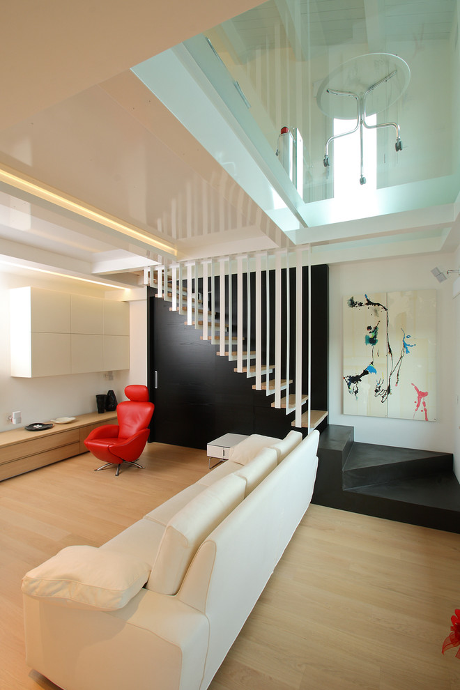 Пример оригинального дизайна: гостиная комната в современном стиле с белыми стенами и светлым паркетным полом