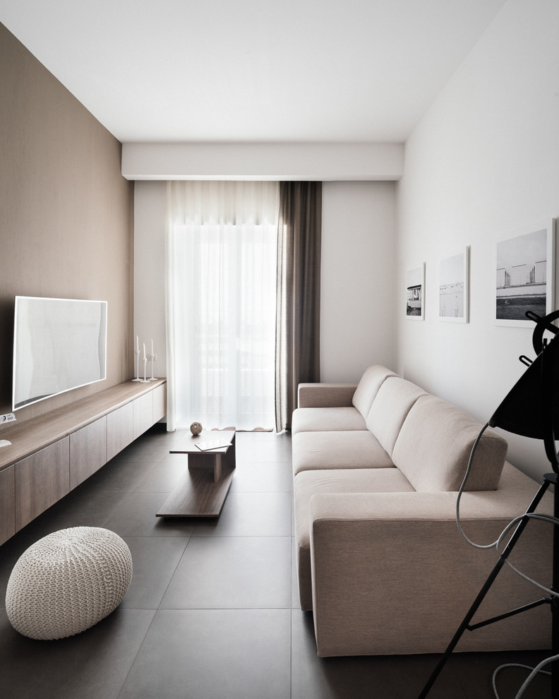 Пример оригинального дизайна: гостиная комната среднего размера в стиле модернизм с белыми стенами и телевизором на стене