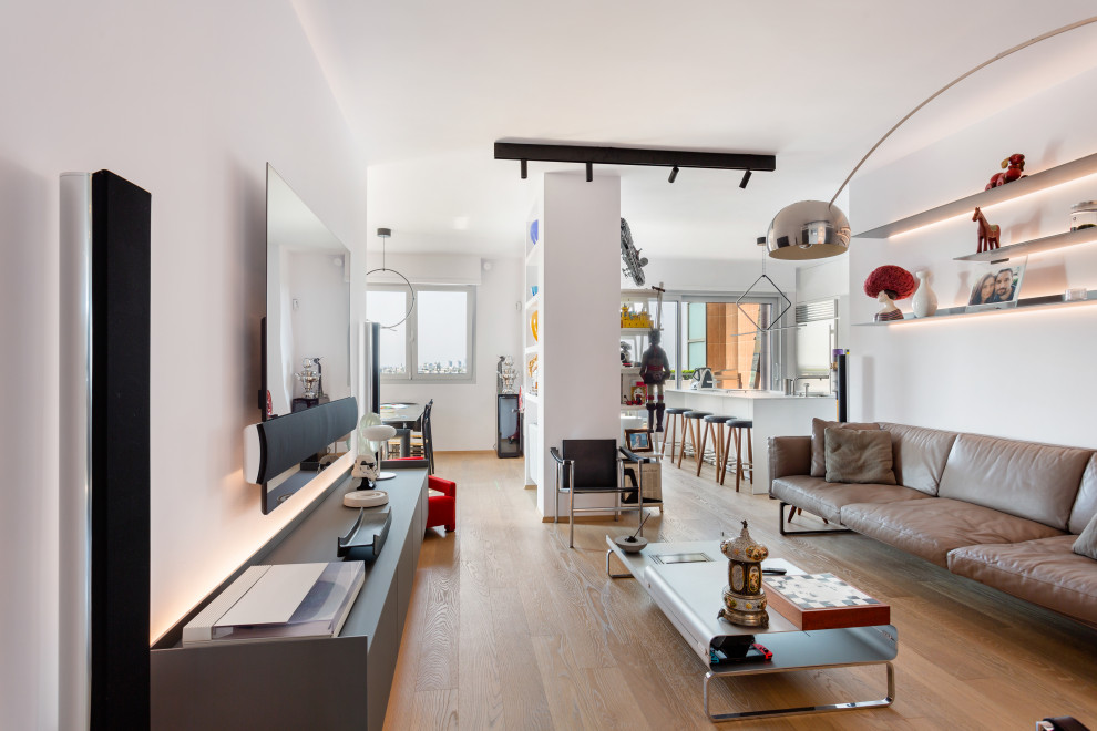 Immagine di un grande soggiorno moderno aperto con angolo bar, pareti bianche, parquet chiaro e TV a parete