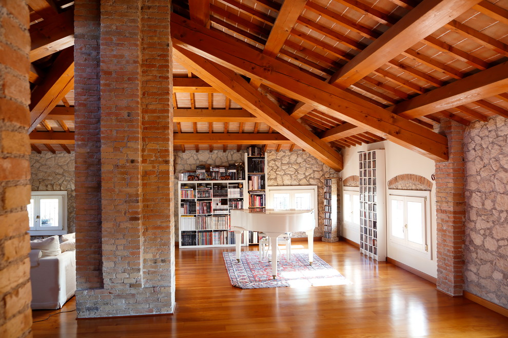 This is an example of a classic open plan games room in Venice with a music area, medium hardwood flooring and brown floors.