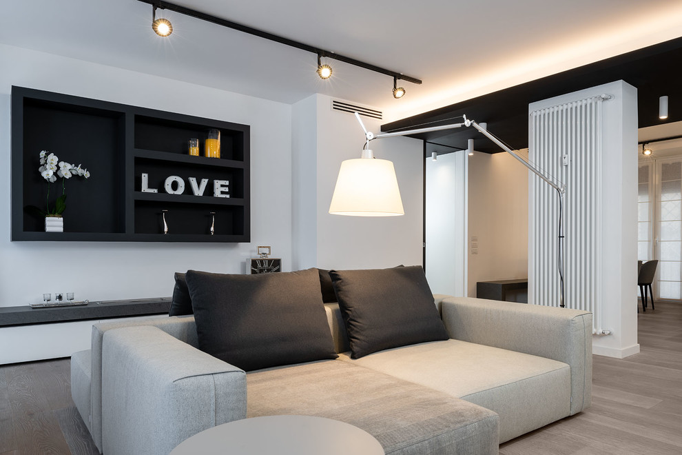 Immagine di un ampio soggiorno design stile loft con pareti bianche, parquet chiaro e pavimento grigio