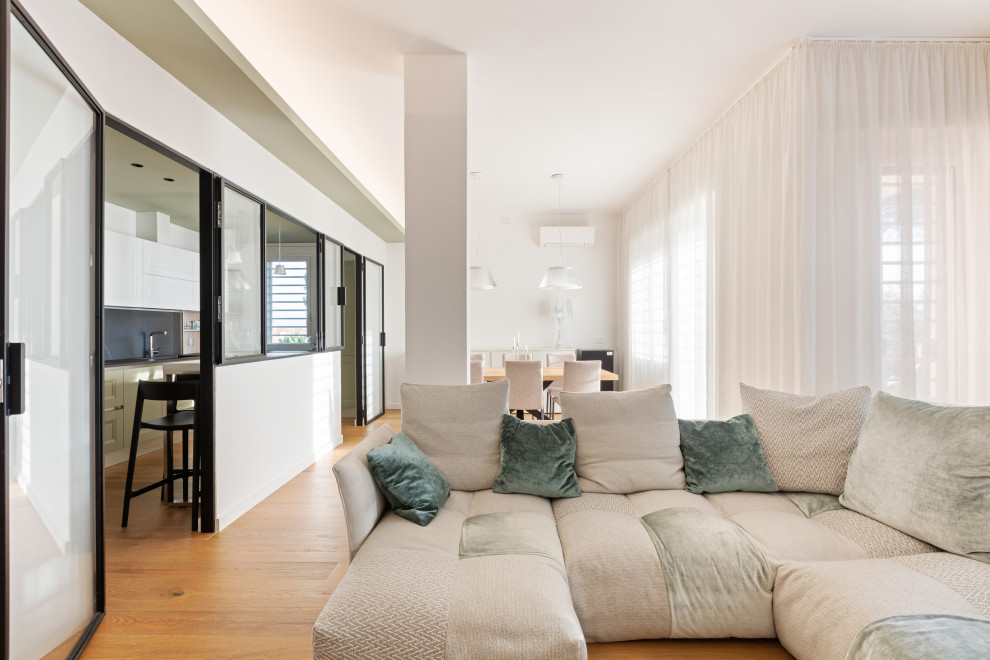 Immagine di un ampio soggiorno contemporaneo aperto con pareti bianche, pavimento in gres porcellanato, parete attrezzata e pavimento marrone