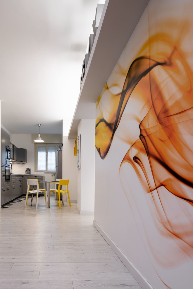 Inredning av ett modernt mellanstort loftrum, med flerfärgade väggar, laminatgolv, en fristående TV och grått golv