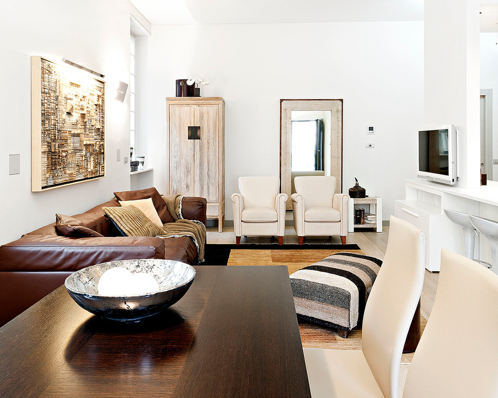 На фото: открытая гостиная комната в современном стиле с белыми стенами и телевизором на стене с