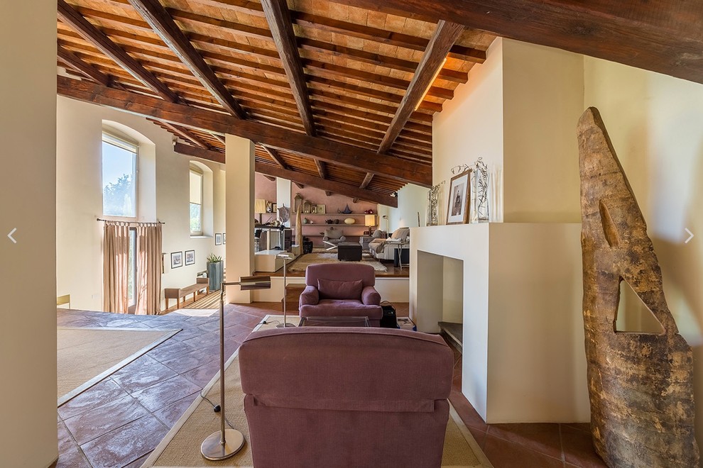 Inspiration for an expansive rural games room in Florence with a music area, white walls, terracotta flooring, a standard fireplace, a stone fireplace surround and a built-in media unit.