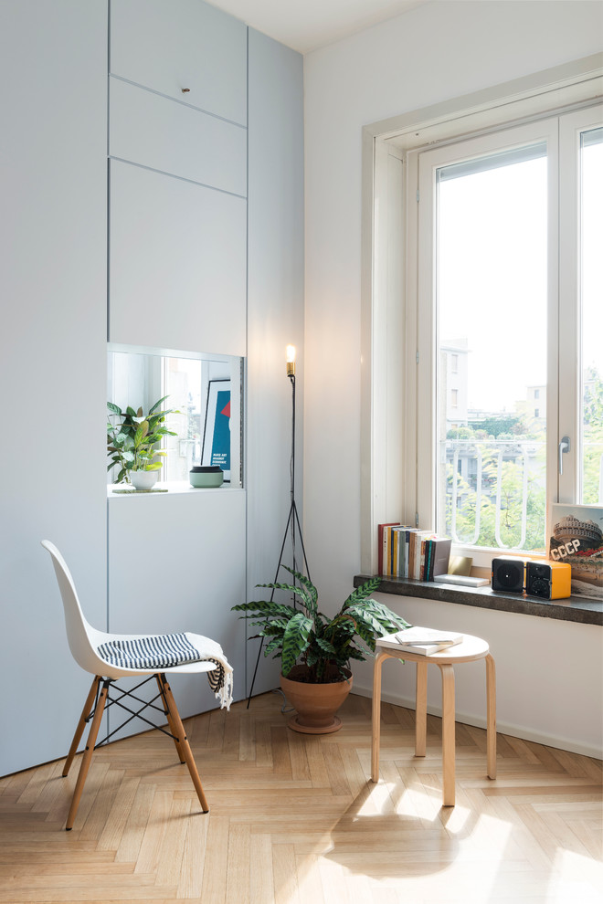 Идея дизайна: гостиная комната в современном стиле с белыми стенами и светлым паркетным полом