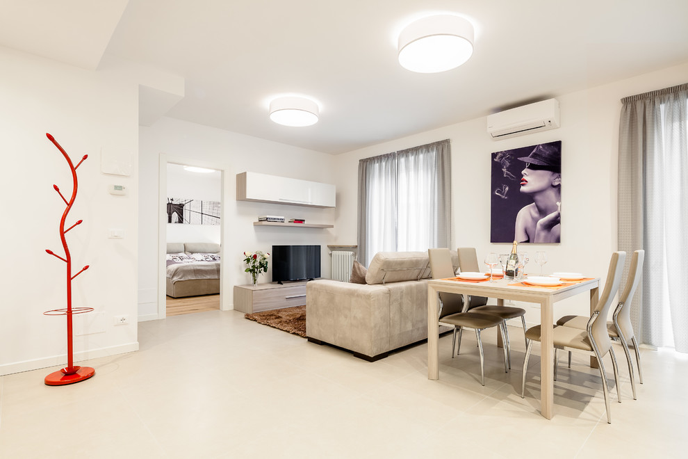 Offenes Modernes Wohnzimmer mit weißer Wandfarbe, beigem Boden, Porzellan-Bodenfliesen und freistehendem TV in Sonstige