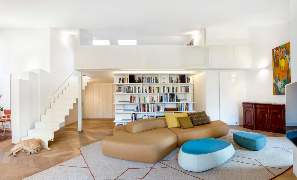 Immagine di un ampio soggiorno contemporaneo aperto con libreria, pareti bianche e parquet chiaro