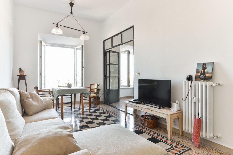 Imagen de sala de estar mediterránea con paredes blancas y televisor independiente