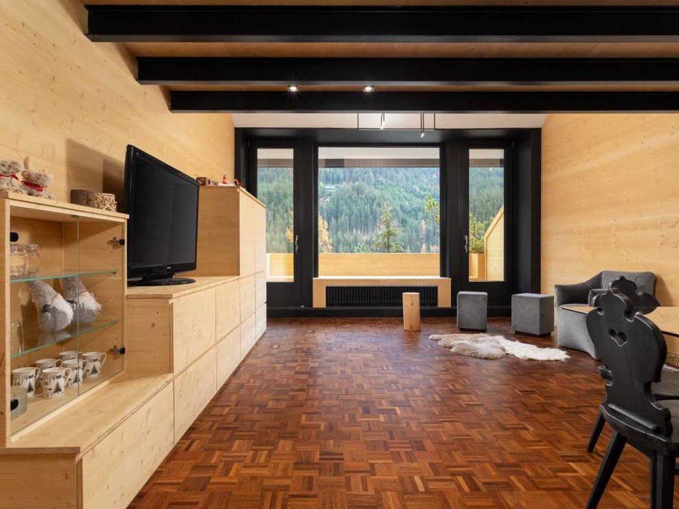 Esempio di un soggiorno moderno di medie dimensioni e aperto con pavimento in legno massello medio, TV autoportante e pavimento marrone