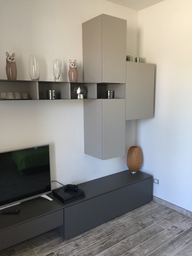 Immagine di un piccolo soggiorno minimalista chiuso con sala giochi, pareti bianche, pavimento in gres porcellanato e TV autoportante