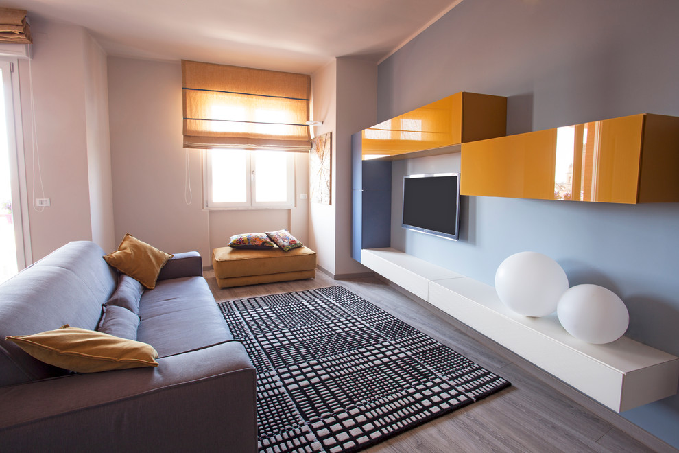 Immagine di un soggiorno contemporaneo chiuso con pareti bianche, parquet chiaro e TV a parete