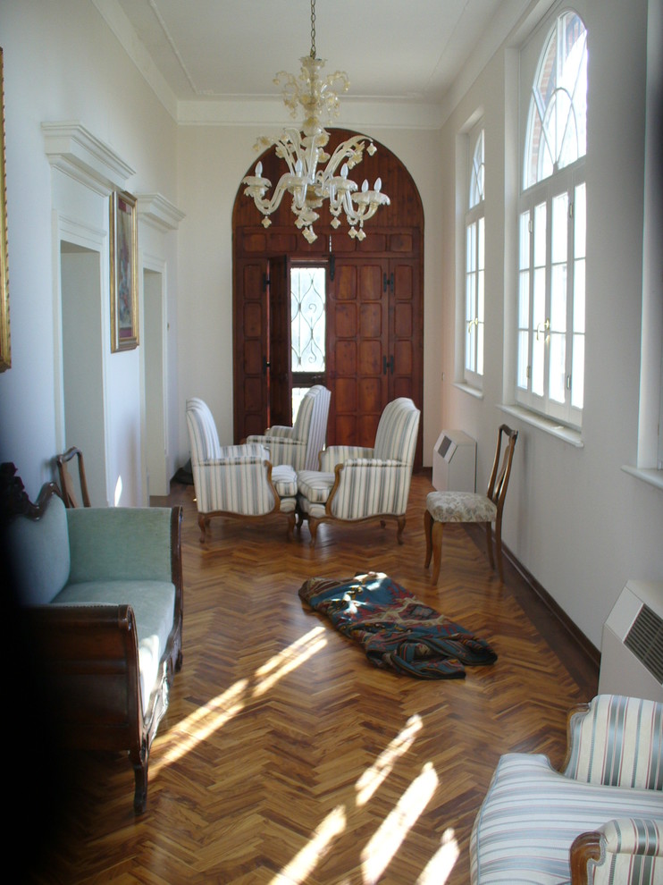 Foto di un soggiorno chic di medie dimensioni e aperto con pareti bianche, pavimento in legno massello medio e nessuna TV