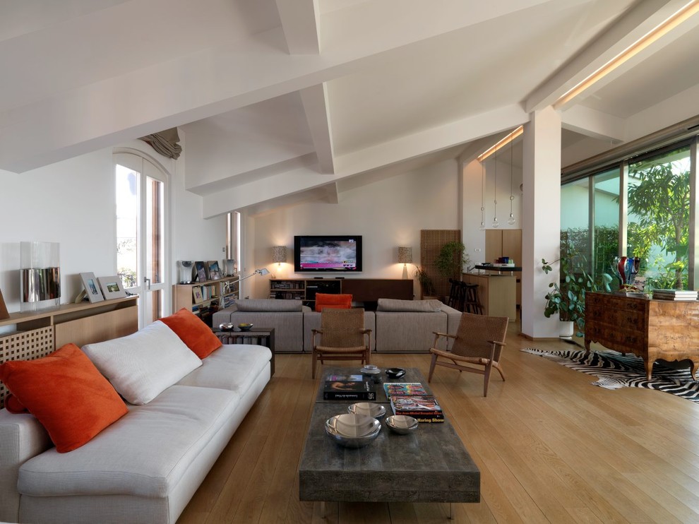 Esempio di un grande soggiorno design aperto con angolo bar, pareti bianche, parquet chiaro, TV a parete e pavimento marrone