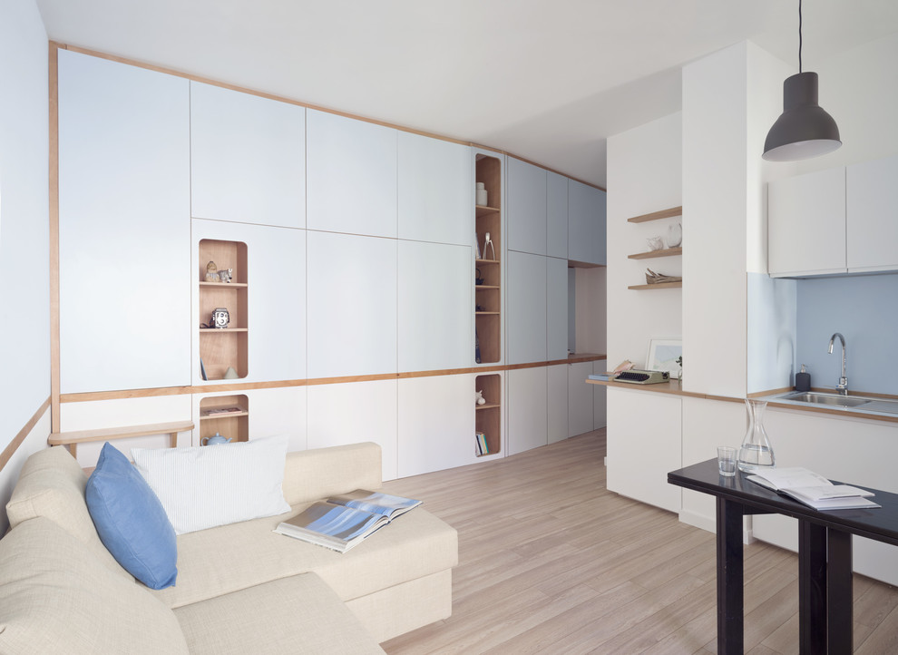 Foto di un piccolo soggiorno stile marino aperto con libreria, pareti blu, pavimento in laminato, TV a parete e pavimento beige