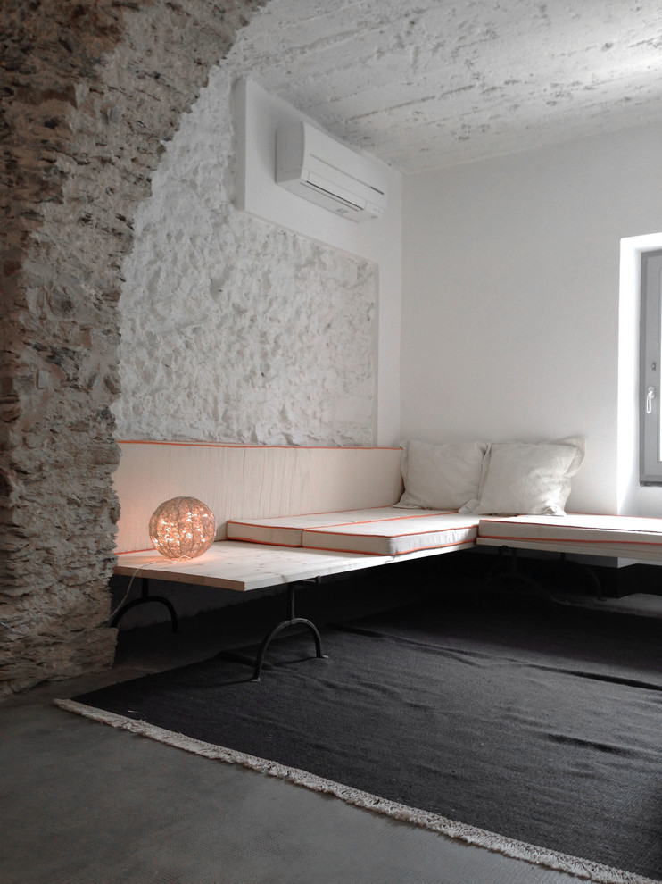 Свежая идея для дизайна: изолированная гостиная комната в современном стиле с белыми стенами и бетонным полом - отличное фото интерьера