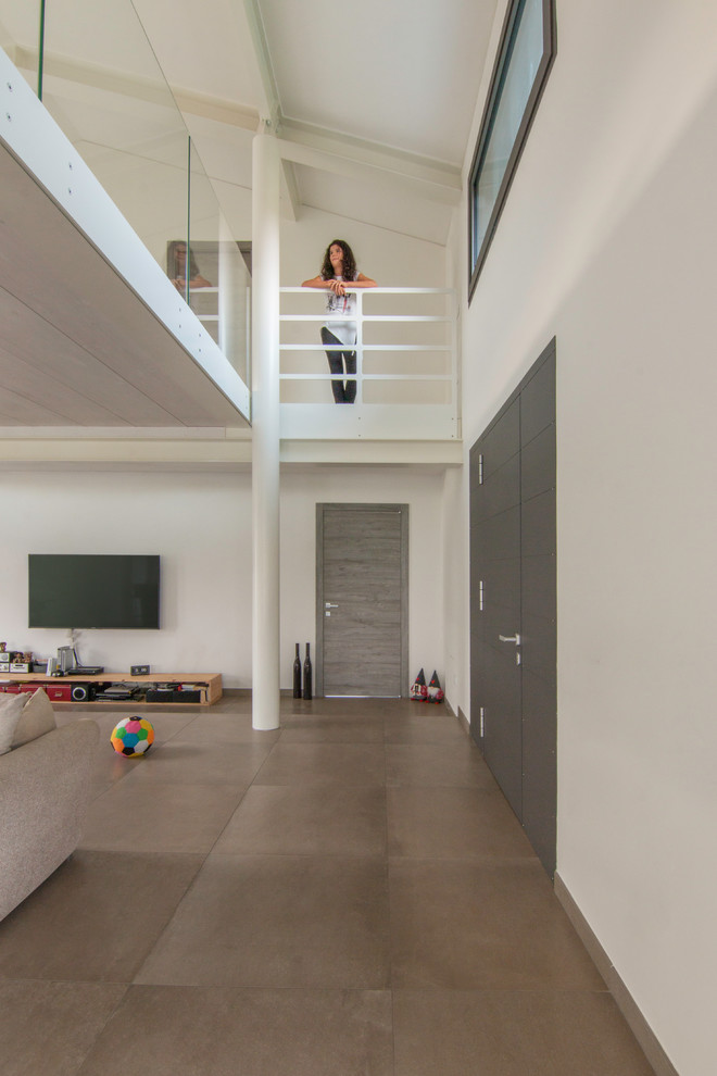 Idee per un soggiorno contemporaneo di medie dimensioni e aperto con sala giochi, pareti bianche, pavimento in gres porcellanato, TV a parete e pavimento grigio