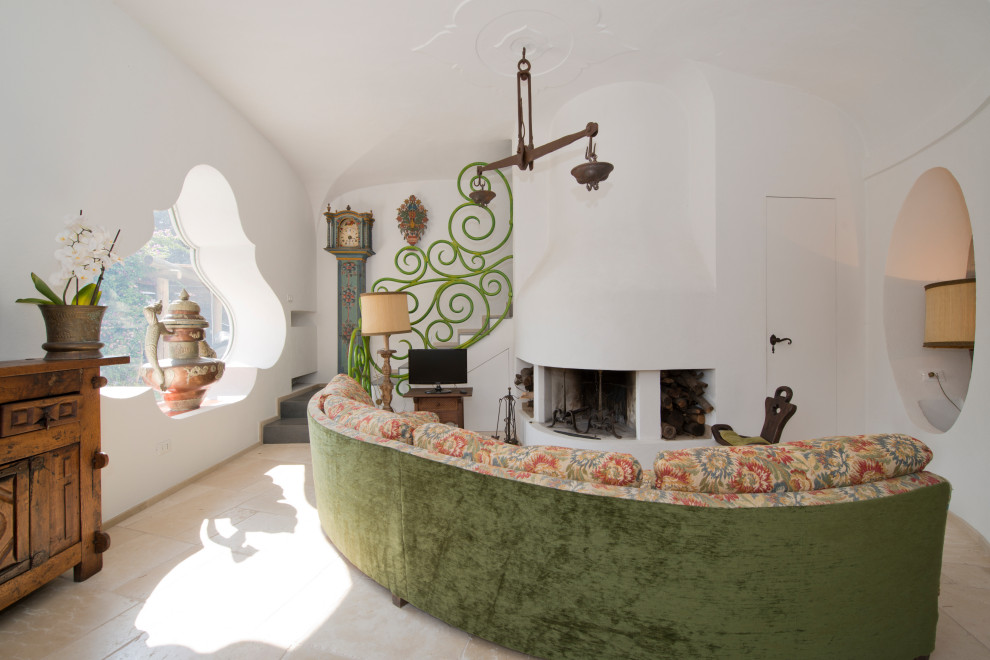 Стильный дизайн: огромная гостиная комната в средиземноморском стиле с белыми стенами, сводчатым потолком, стандартным камином, фасадом камина из штукатурки и отдельно стоящим телевизором - последний тренд