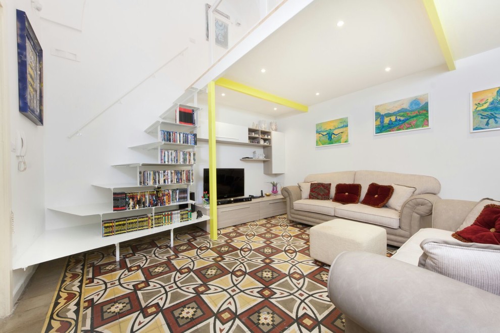 Esempio di un piccolo soggiorno contemporaneo aperto con libreria, pareti bianche, pavimento in cemento, nessun camino, parete attrezzata e pavimento multicolore